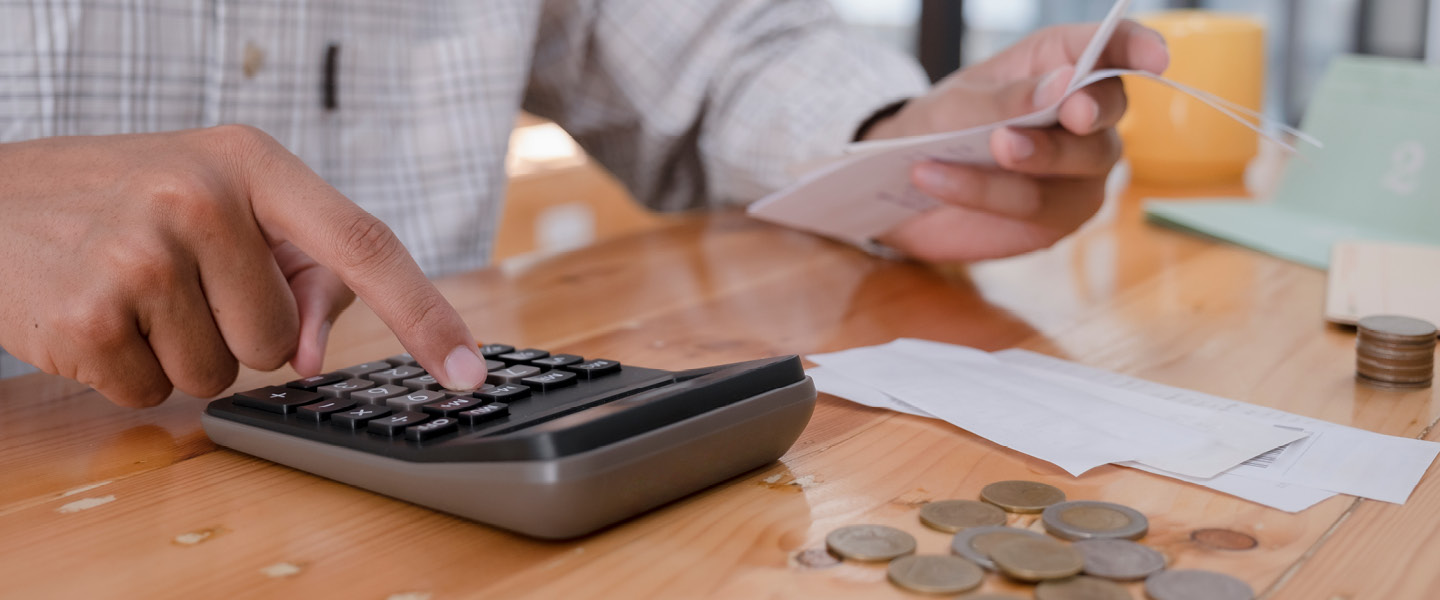 accountant calculating bill with coins in background
