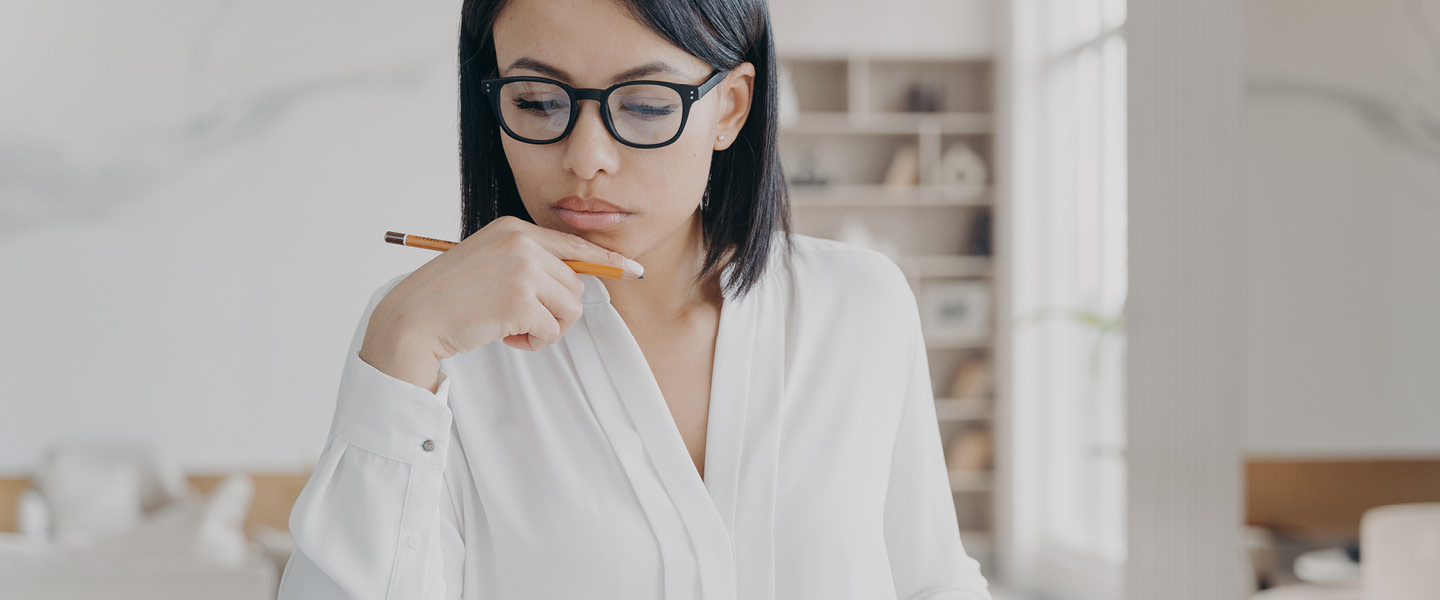 Business woman in glasses counting profit on calculator