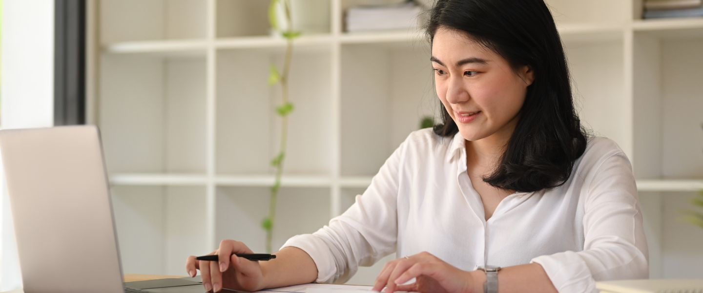 focused asian woman employee using calculator and laptop