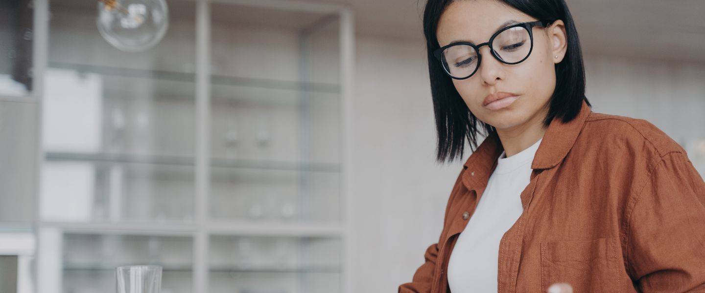 focused female in glasses counting expenses on calculator