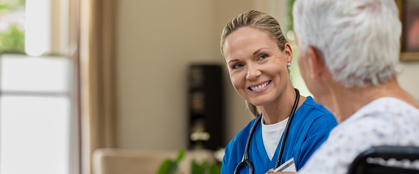 Friendly nurse talking to senior patient