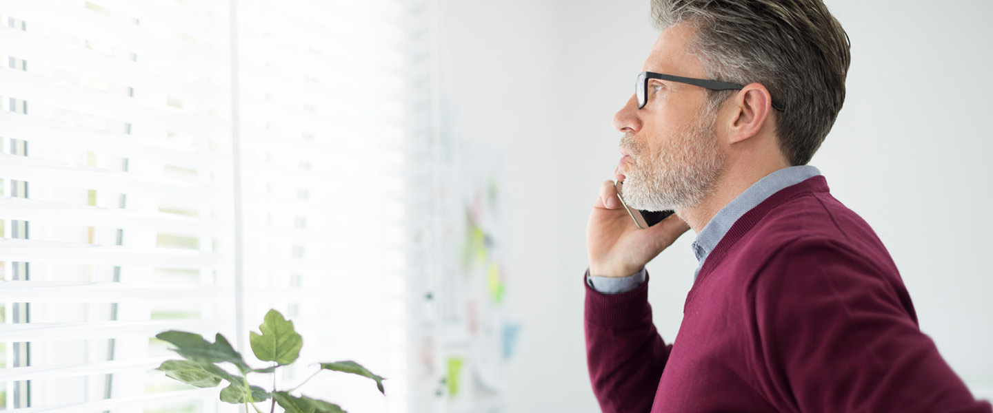 man calling client next to window