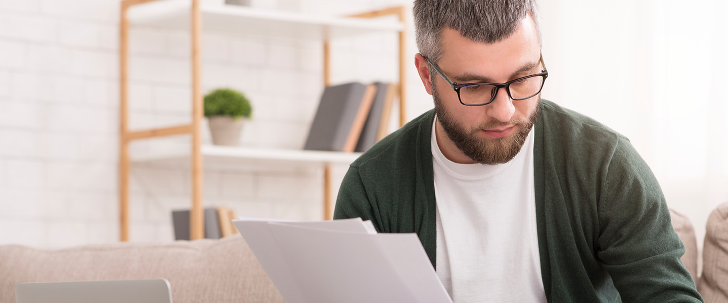 man with calculator counting money and checking bills