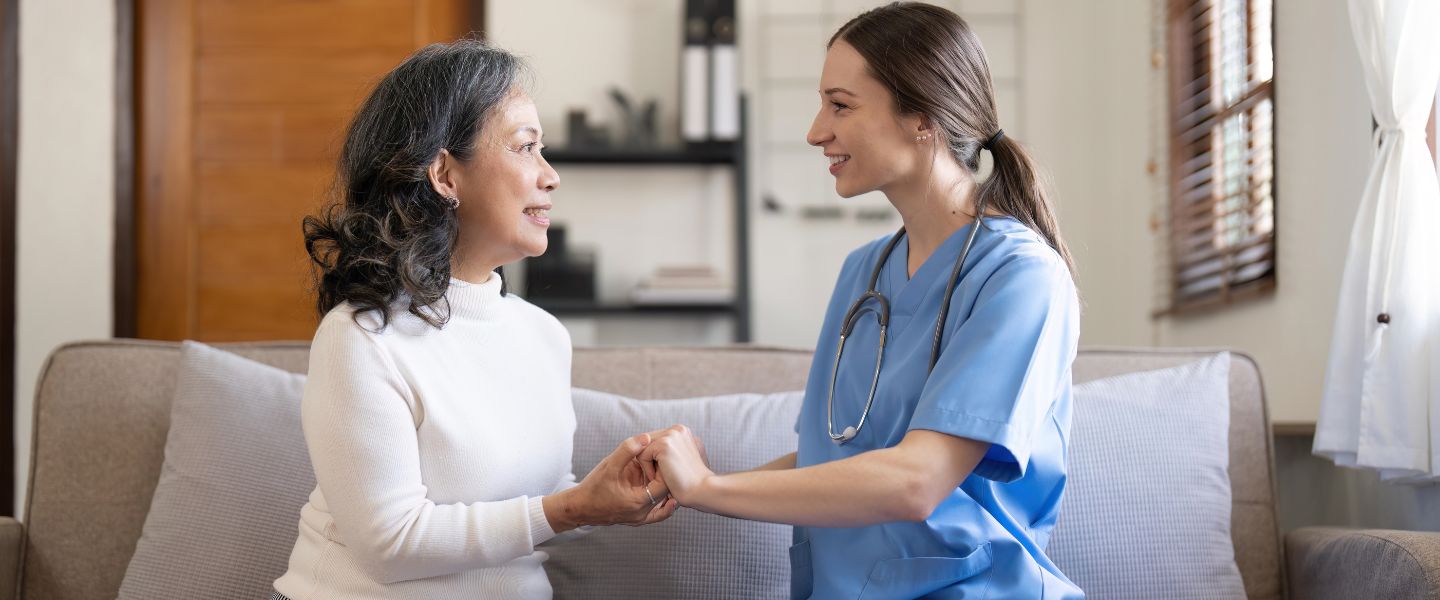 nurse and senior patient hold hands