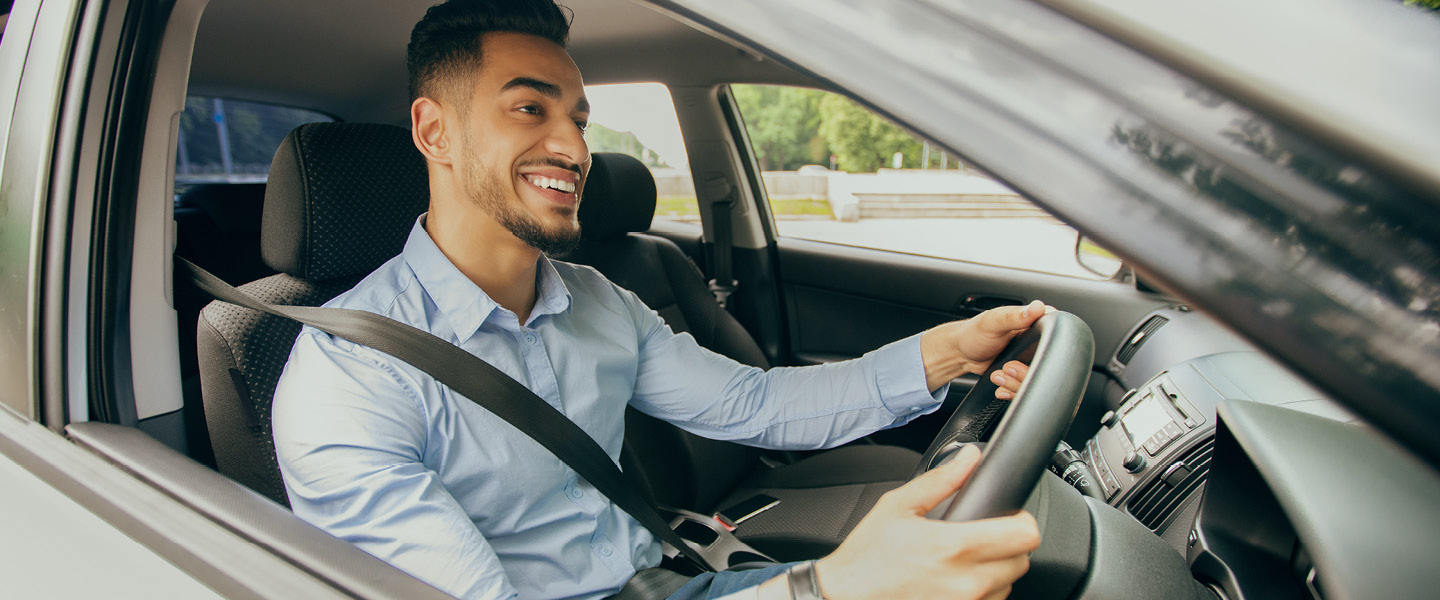 positive middle eastern guy going to office driving