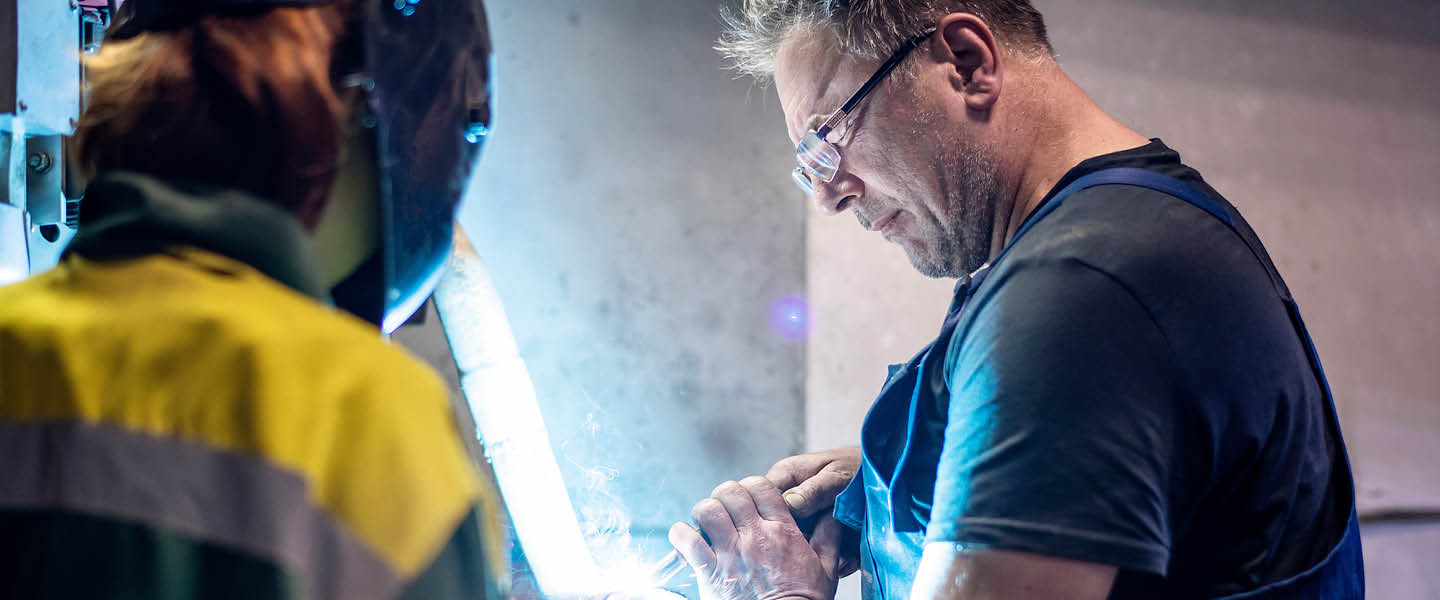 professional welder in protective uniform and mask