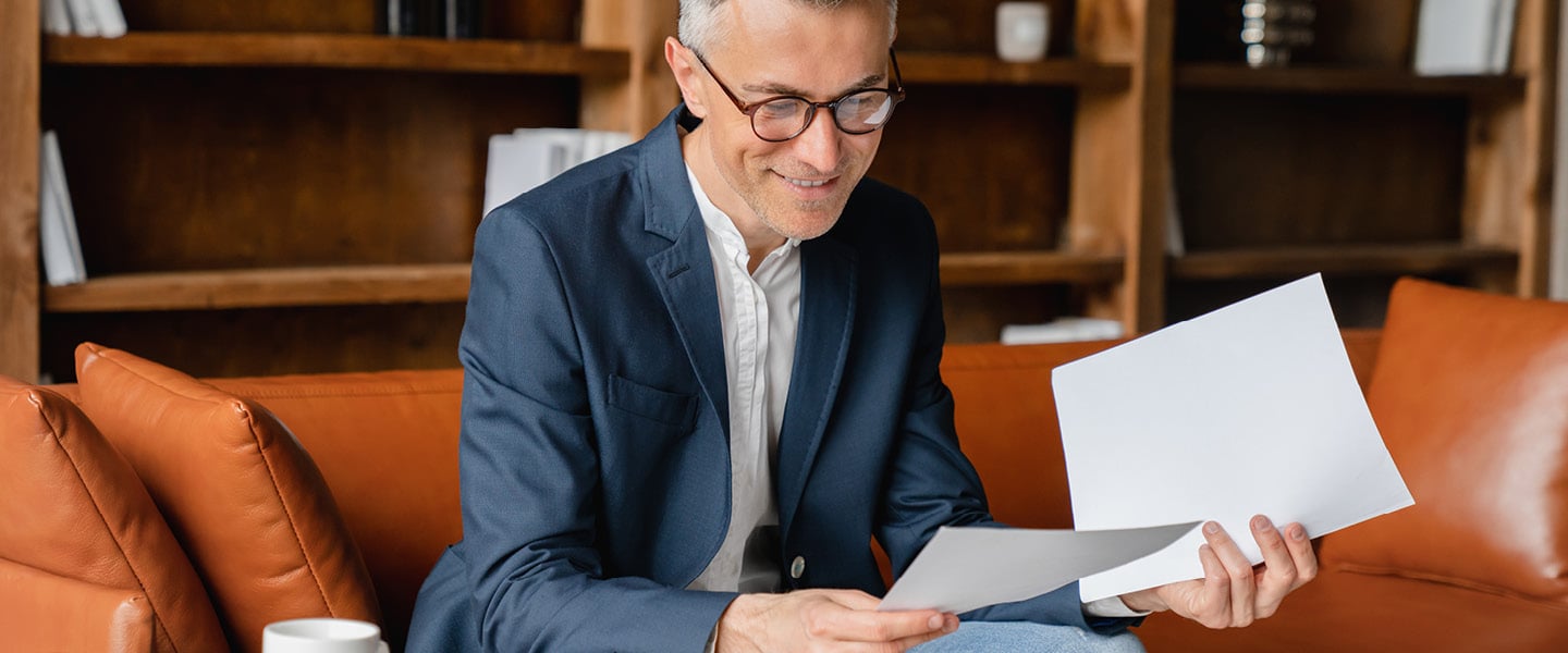 mature businessman holding papers in an office