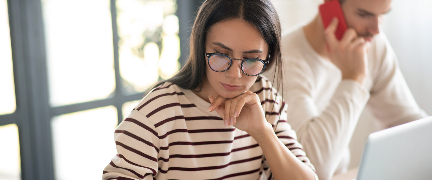 wife wearing glasses feeling busy while filling taxes