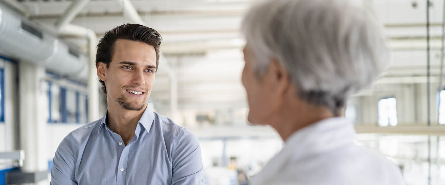 smiling businessman talking to senior businesswoman