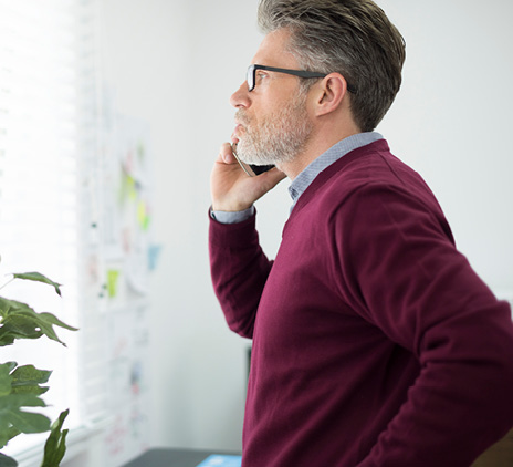 man calling client next to window