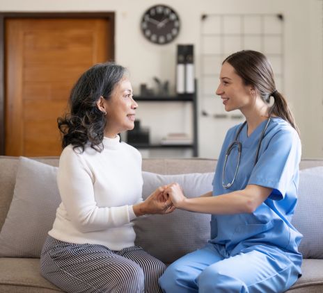 nurse and senior patient hold hands