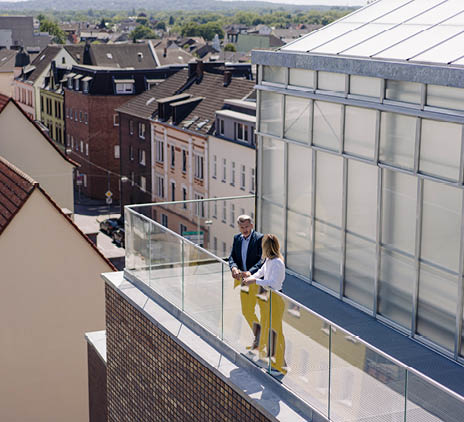 Man and woman talking on balcony with a view