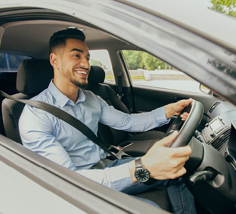 positive middle eastern guy going to office driving