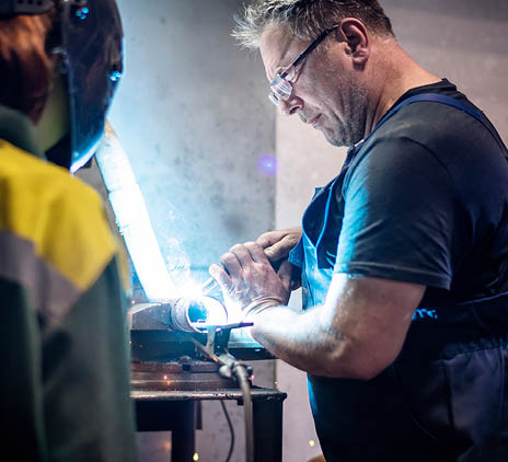 professional welder in protective uniform and mask