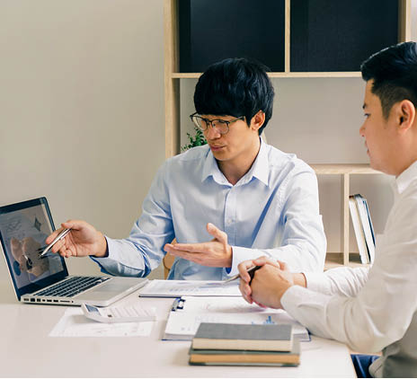 Young man explaining model to another young man 