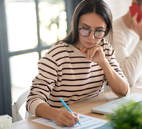 wife wearing glasses feeling busy while filling taxes
